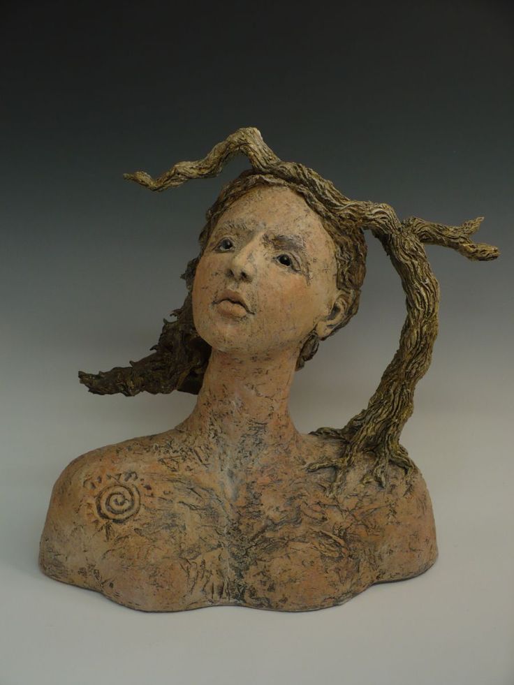 a sculpture of a woman's head with branches in her hair