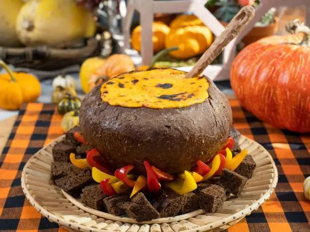 there is a cake made to look like a monster on a plate with other food items in the background