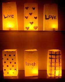 some paper bags that are lit up in the dark with love written on them and hearts