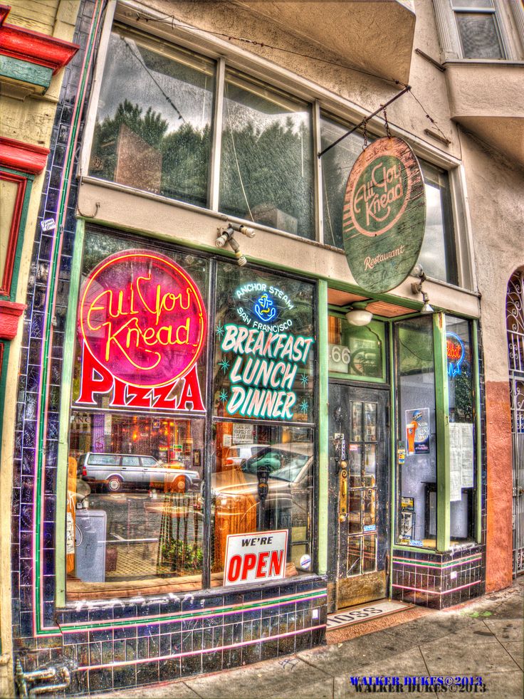 the front of a restaurant with many signs on it's windows and signage above the doors