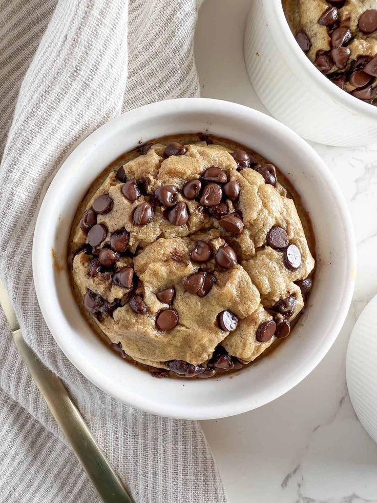 two white bowls filled with chocolate chip cookies