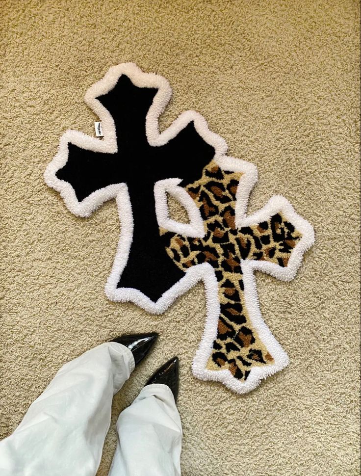 someone is laying on the floor next to an animal print cross