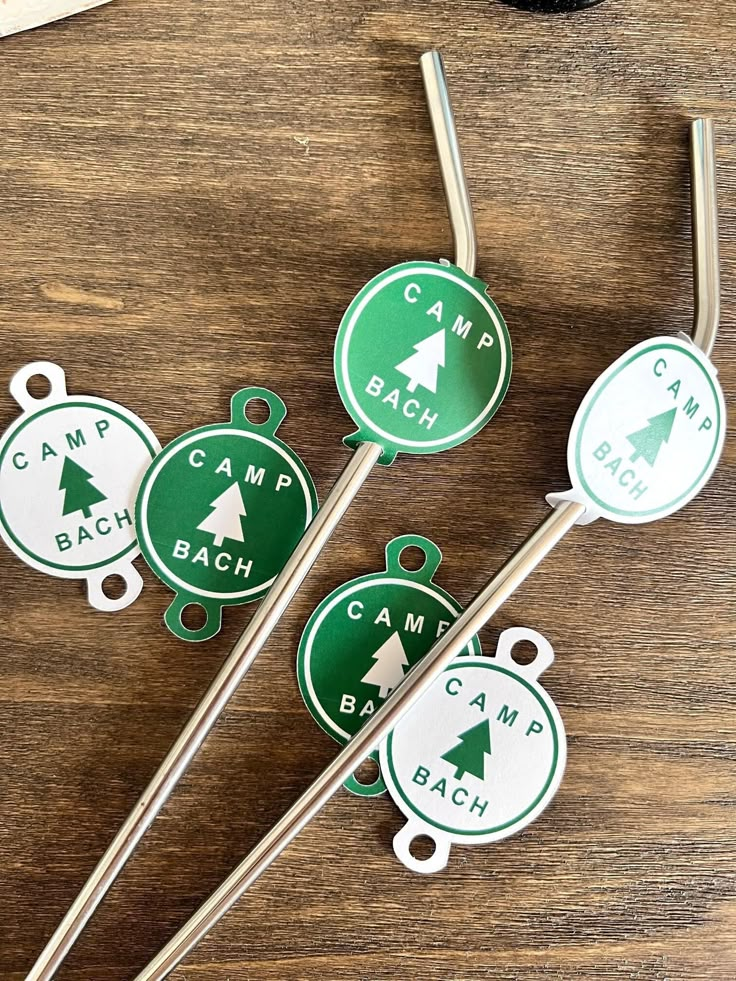 four green and white stickers with trees on them sitting next to a pair of scissors