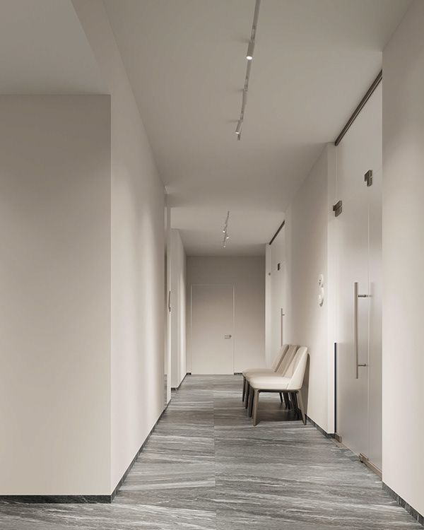 an empty hallway with white walls and benches