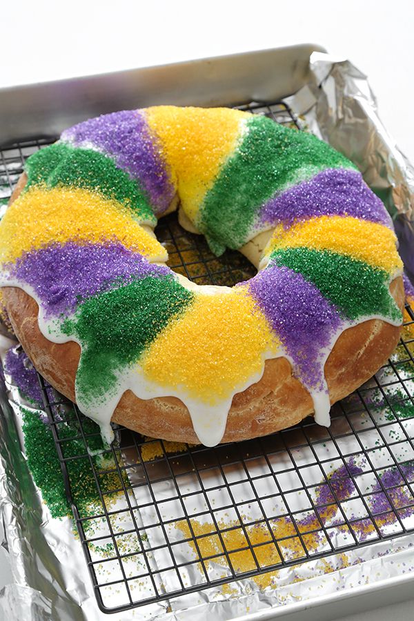 a doughnut covered in icing and sprinkles on a cooling rack