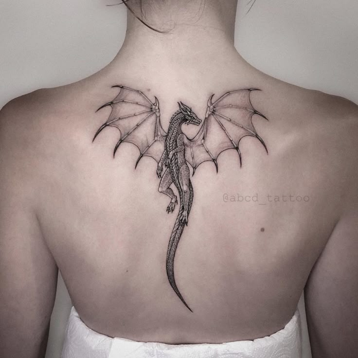 a woman with a dragon tattoo on her back