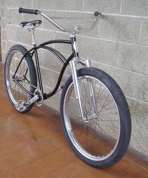 a black and silver bicycle leaning against a brick wall