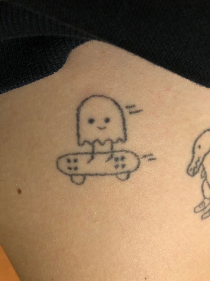 a person with a tattoo on their back has a skateboard in front of them