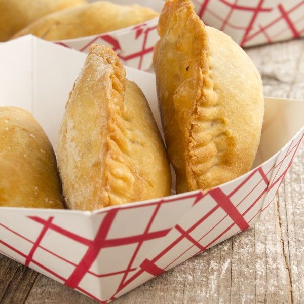 several pastries in red and white boxes on a wooden table