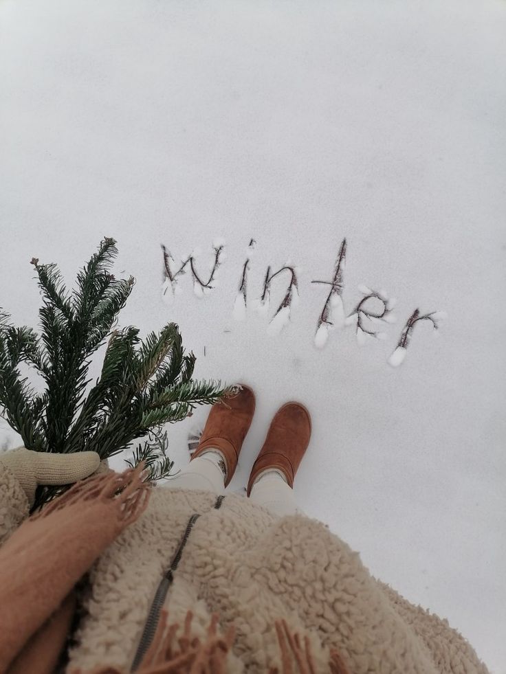 someone standing in the snow with their feet up