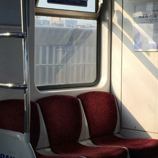 two red seats on a train next to a window