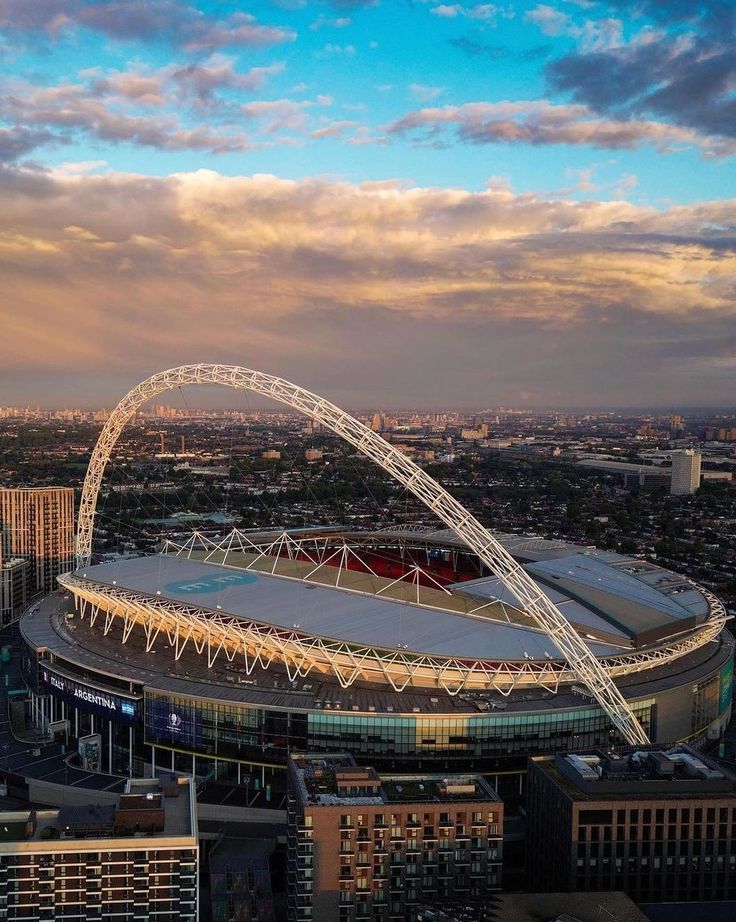 an aerial view of the emirates stadium in london, england at sunset or dawn with dramatic clouds