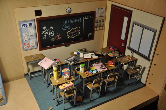 a classroom with desks and chairs in front of a chalkboard