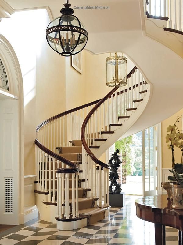 a spiral staircase in an elegant home with black and white checkered flooring, chandelier hanging from the ceiling