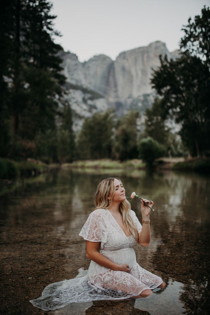 a pregnant woman sitting in the water eating something