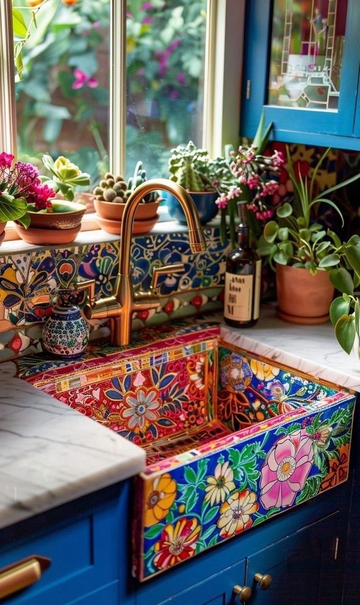 a colorful sink in a kitchen with potted plants on the window sill next to it