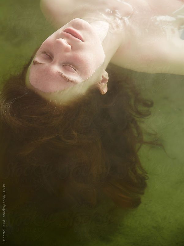 a woman floating in the water with her eyes closed