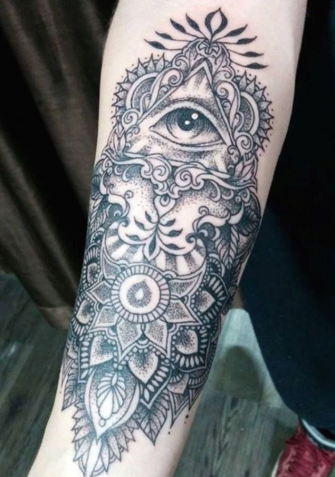 a person with a black and white tattoo on their arm that has an all seeing eye