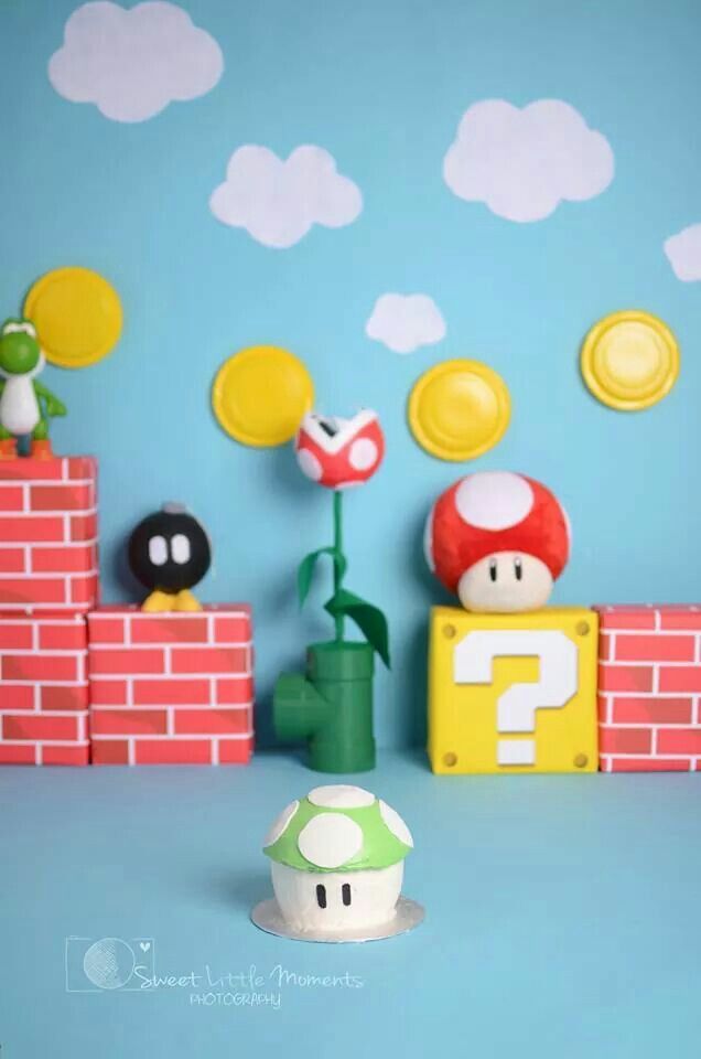 some toys are sitting on top of a blue wall and there is a mario mushroom figure next to it