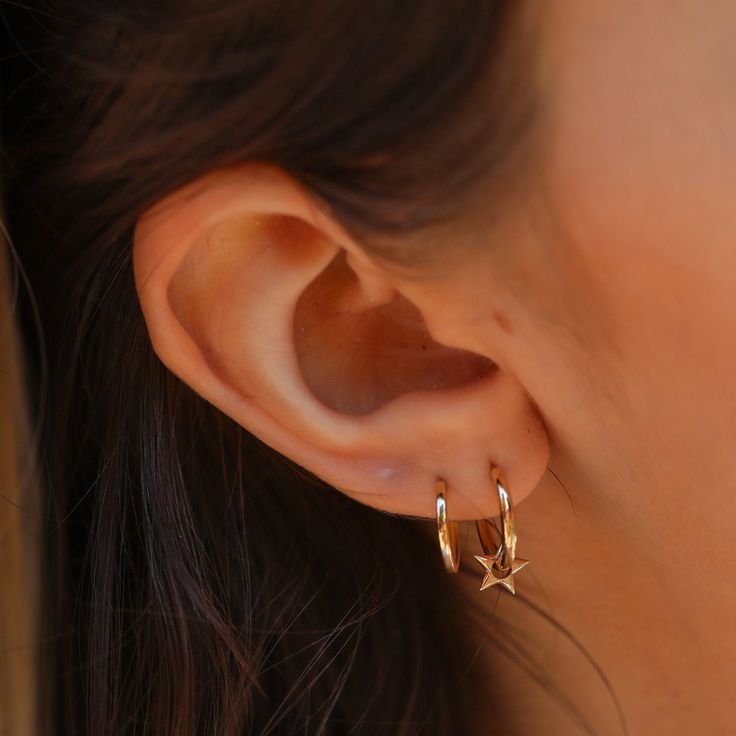 Skylar Baby, you’re a star. Embrace a touch of cosmic charm with these delightful Solid Gold Pointed Star Charm Earrings. Crafted from lustrous 14k gold (available in yellow, white, or rose), these earrings feature dainty star charms that dangle playfully from delicate huggie hoops. Their timeless design adds a subtle shimmer and celestial allure to any outfit. - Handmade- Solid Gold- Diameters: Outer 13 mm - Inner 11 mm- Size of the Star Charm: 7 mm- Hoop Thickness: 1.3 mm * Sold as a pair * Al Gold Huggie Earrings, Gold Huggies, 14k Gold Hoop Earrings, Crescent Necklace, Hoops Gold, Sell Gold, Huggie Earrings, Everyday Earrings, Moon Necklace