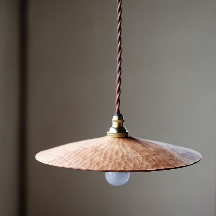 a wooden light hanging from a ceiling with a cord attached to the top of it