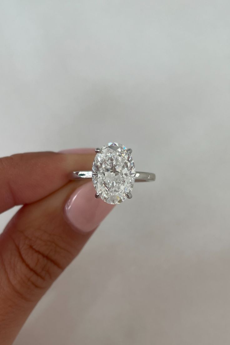 a close up of a person holding a ring with a diamond in it's center