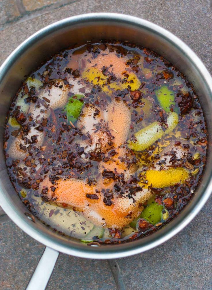 a pot filled with food sitting on top of a cement floor next to a metal spatula