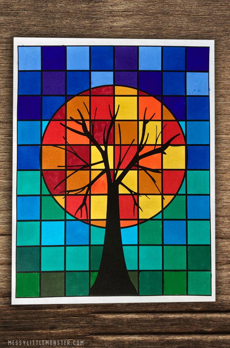 a stained glass window with a tree in the center and colorful squares around it on a wooden surface