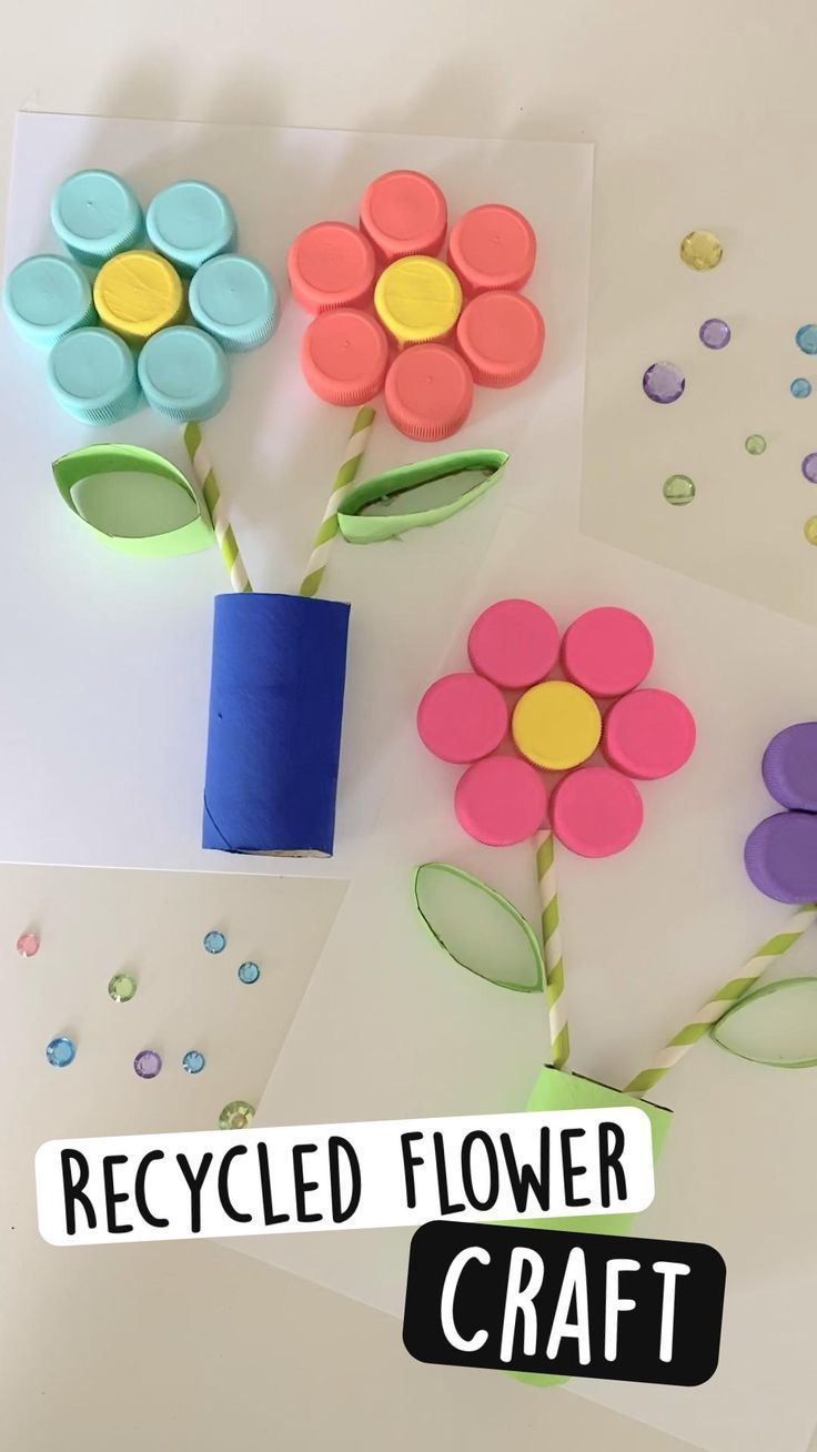 flowers made out of recycled paper are displayed on a table with the words recycled flower craft