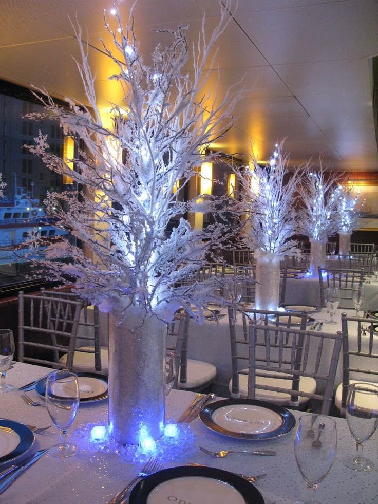 an image of a table setting with white flowers and blue lights on the centerpiece