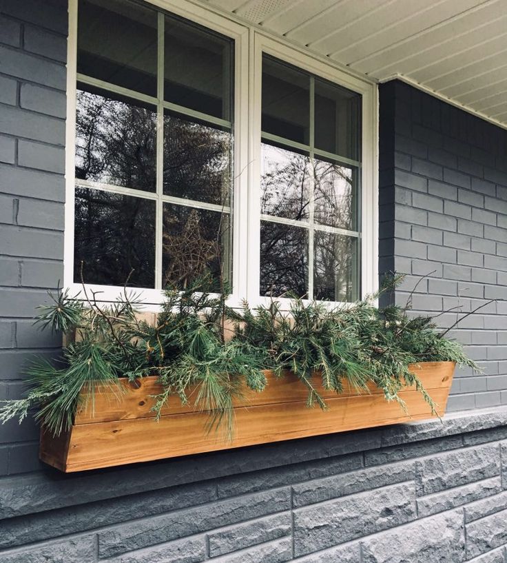 a window box filled with plants on the side of a building