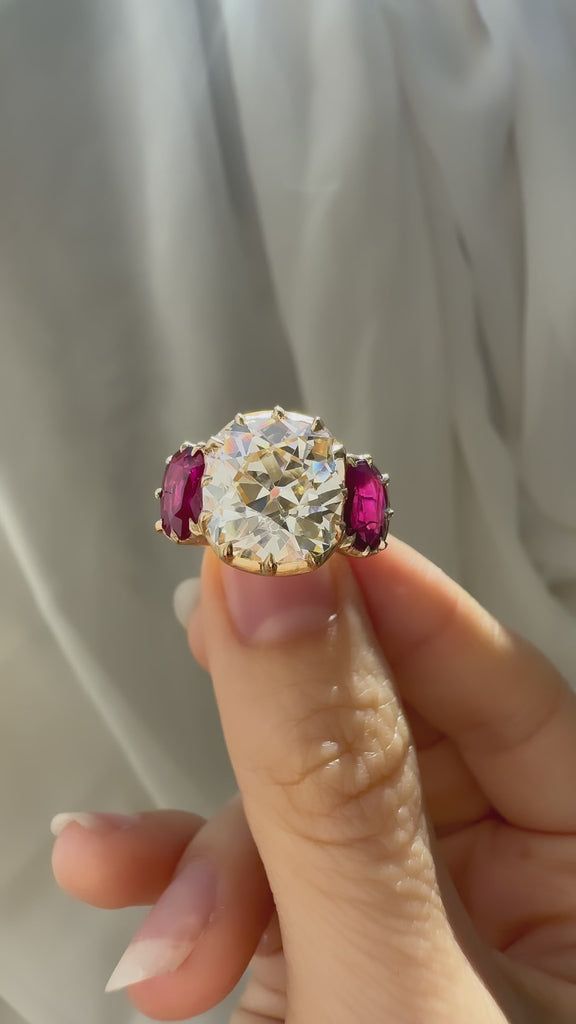 a woman's hand holding an old diamond ring with three stone stones on it