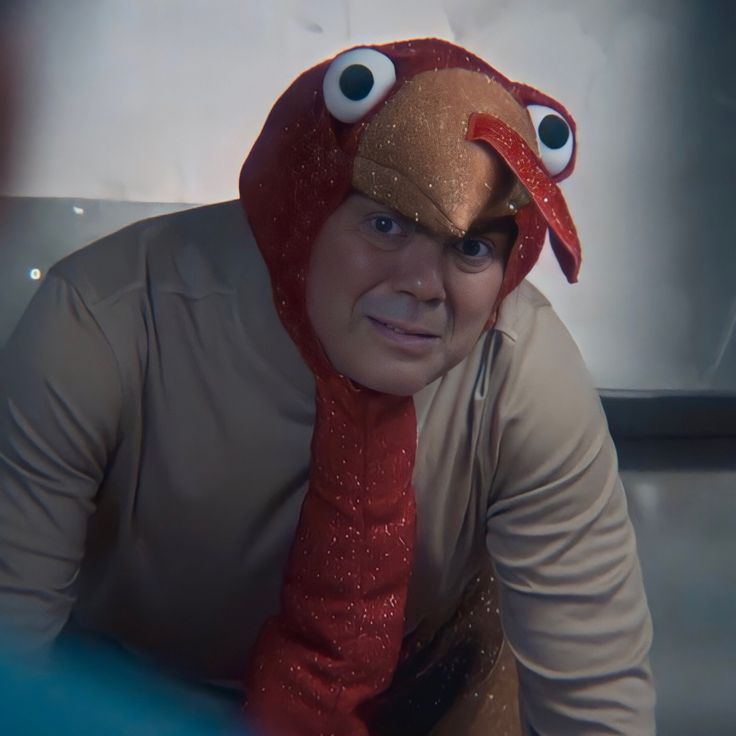 a man wearing a red and gold bird costume