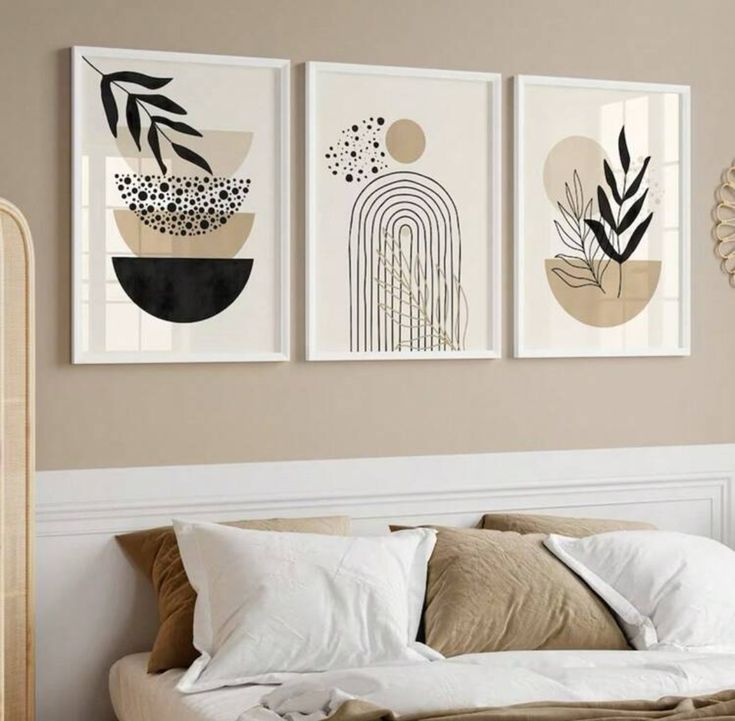 three framed art prints hanging on the wall above a bed in a room with beige walls