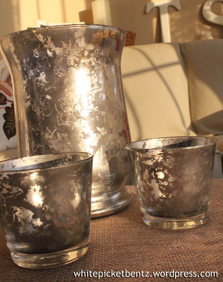 three silver vases sitting on top of a table