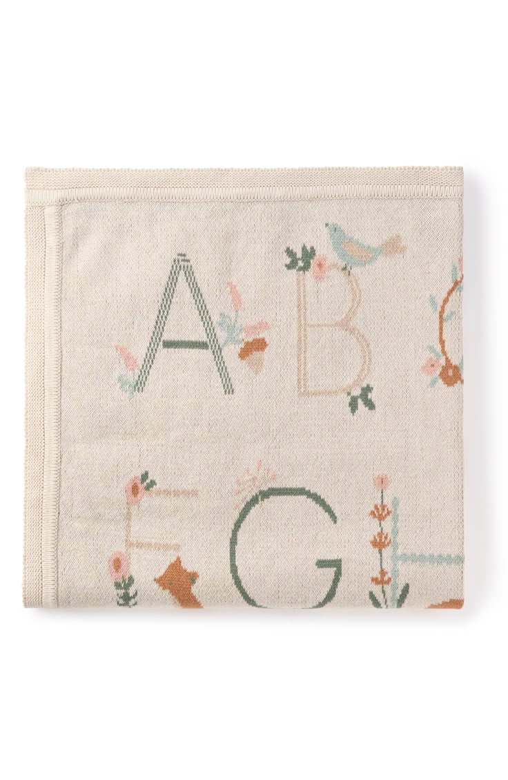 a white pouch with letters and flowers on it