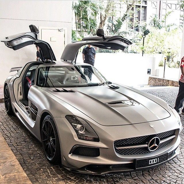 a mercedes sls amg with its hood open and people looking at the car