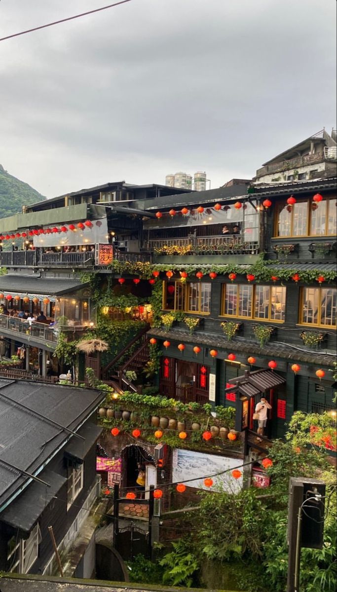 an old building with red lanterns on it's windows and balconies above