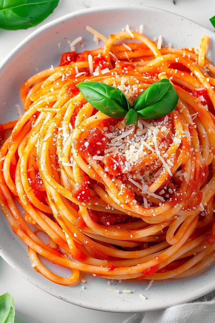 a plate of spaghetti with sauce and parmesan cheese