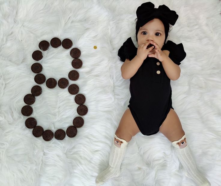 a baby is laying on the floor next to some cookies