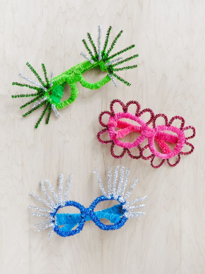 three different colored glasses are sitting on a wooden surface, one is decorated with beads and the other has sequins