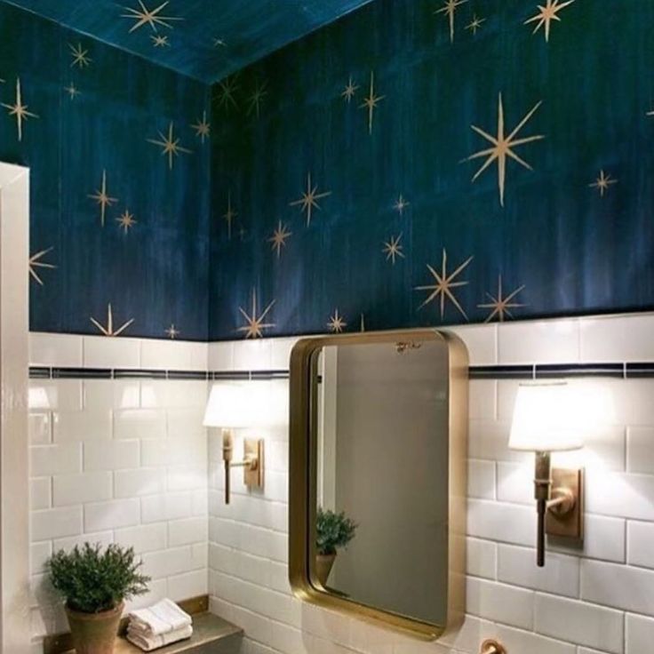 a bathroom with stars painted on the ceiling and white tile walls, along with a gold framed mirror