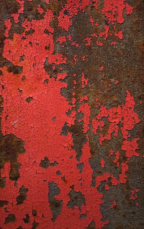 an old rusted metal surface with red paint