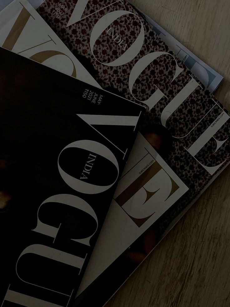 three magazines sitting on top of a wooden table next to each other with the covers folded down