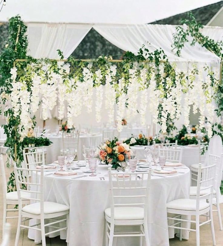 the tables are set with white linens and flowers on them for an elegant wedding reception