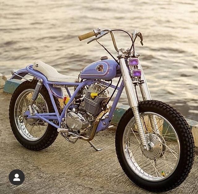 a purple motorcycle parked next to the water