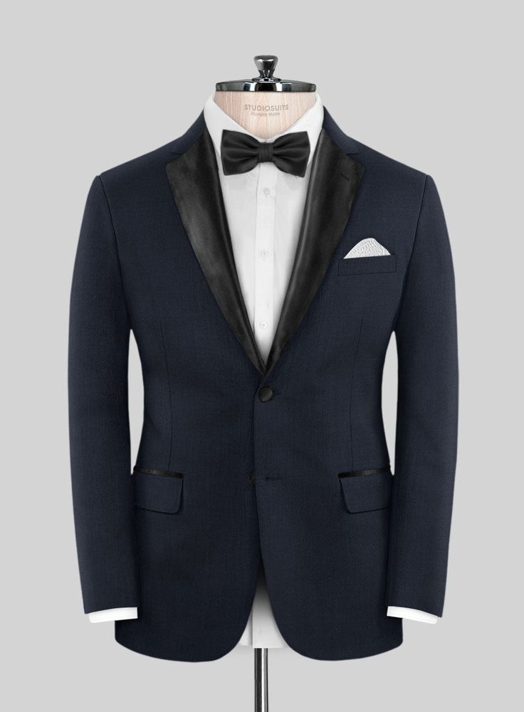 Set your style ablaze with the irresistible allure of the Napoleon Dark Blue Wool Tuxedo Suit. Meticulously crafted from the finest premium wool, this tuxedo features a deep, rich blue hue that adds a subtle yet striking visual appeal to your ensemble. Whether you're attending a black-tie gala, a luxury wedding, or a formal evening soirée, the Napoleon Dark Blue Wool Tuxedo Suit is your ticket to commanding attention and making an unforgettable impression.  Featuring satin lapel, matching satin Elegant Single Button Blue Tuxedo, Custom Fit Tuxedo Suits For Tailoring, Evening Tuxedo With Notch Lapel In Suiting Fabric, Tailored Tuxedo Three-piece Suit For Evening, Evening Tuxedo Three-piece Suit Tailored, Tailored Evening Tuxedo Three-piece Suit, Tailored Tuxedo For Semi-formal Occasions, Fitted Tuxedo With Hidden Button Closure For Evening, Evening Fitted Tuxedo With Hidden Button Closure