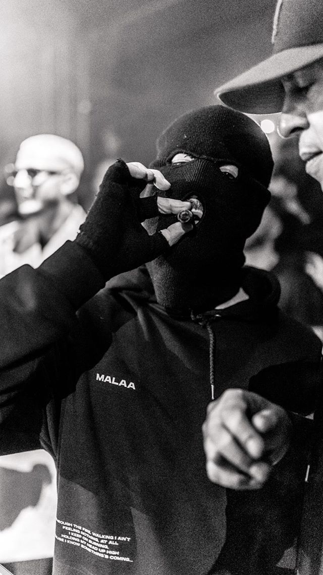 a group of men standing next to each other in front of a crowd wearing face masks