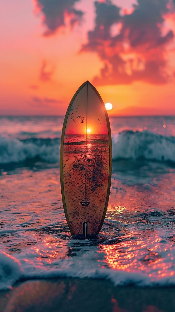 a surfboard sitting in the water at sunset