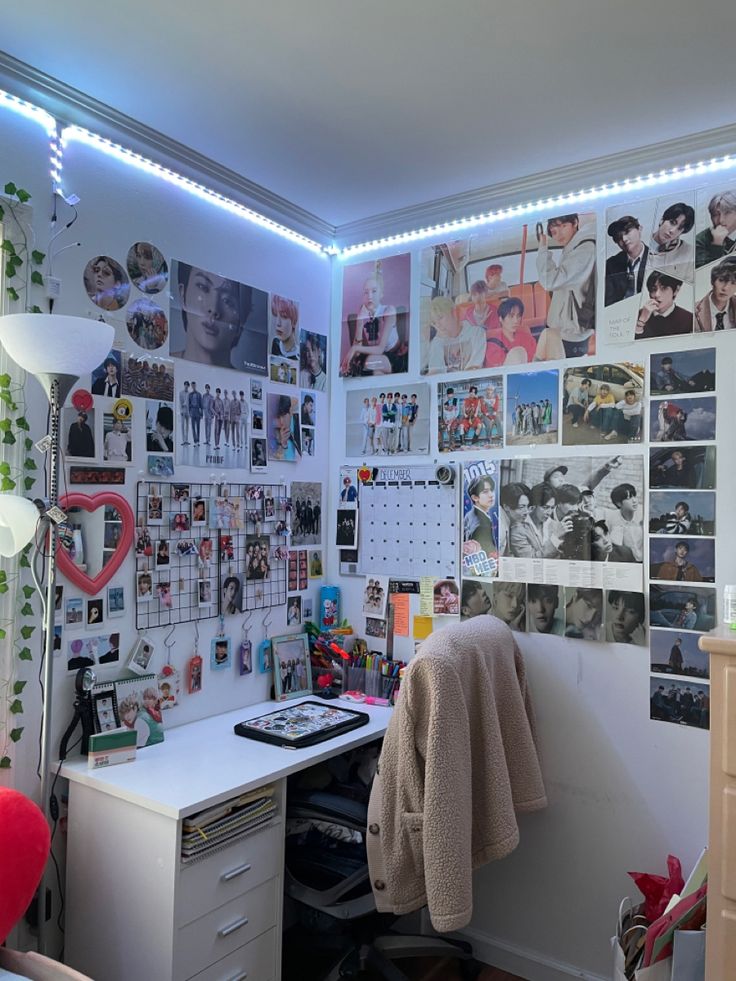 a room with many pictures on the wall and a desk in front of some drawers